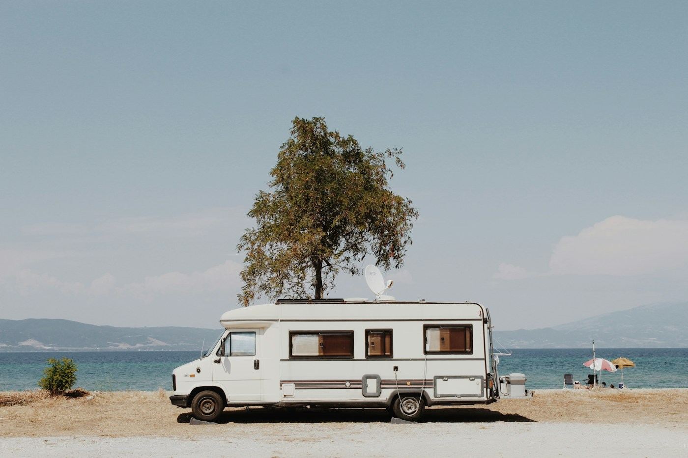 Camper van parked on a beach on a sunny day